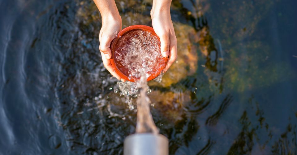 Water flows into a vessel cupped by two hands in a metaphor for how remaining in good standing in California eases the way for donations.