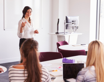 A teacher stands in front of a class.