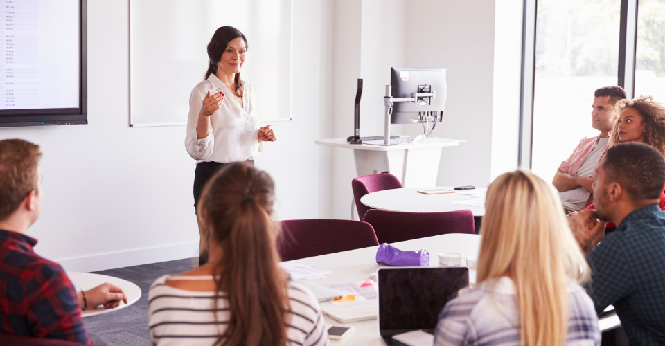 A teacher stands in front of a class.