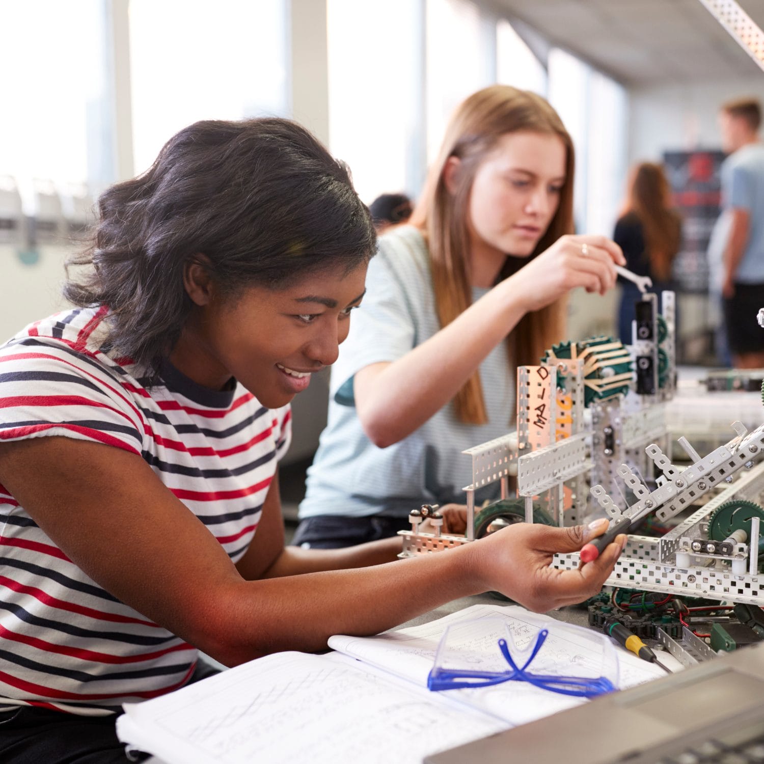 High school students look over test tubes and a microscope.